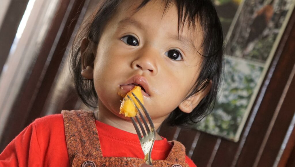 Criança indígena da região do Rio Chandless se alimenta com pedacinhos de mamão. Região é farta em biodiversidade. Foto: Odair Leal/Secom