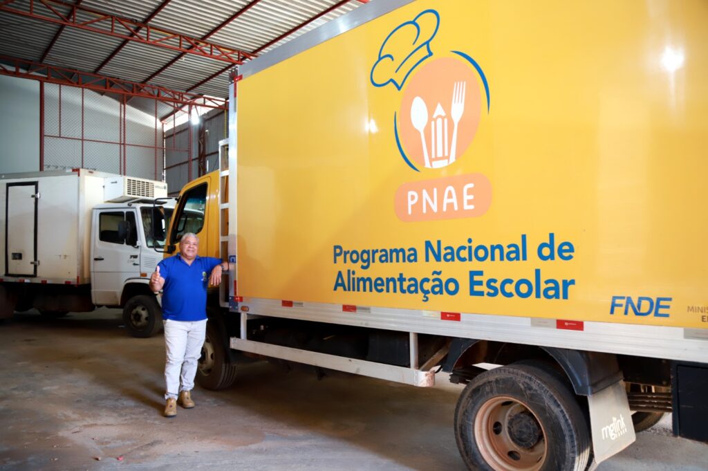Motorista João de Deus de Pontes posa ao lado do caminhão da frota de entrega de alimentos. Foto: Mardilson Gomes/SEE