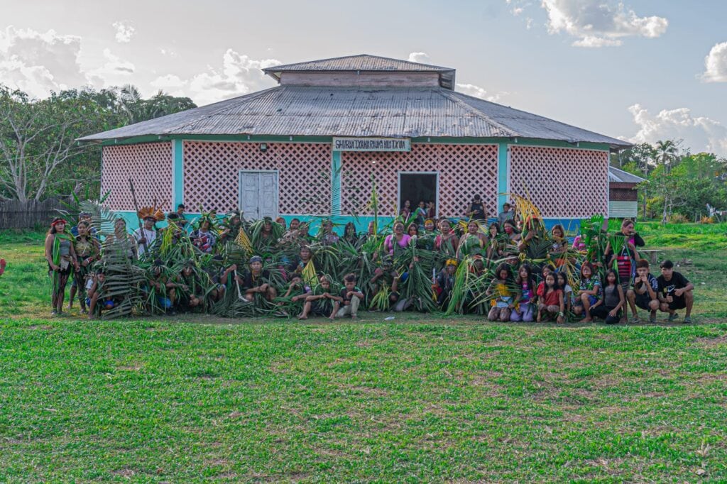 Alunos da Escola Indígena Huni Kuin Tuwe em frente à unidade, símbolo de força, identidade e protagonismo juvenil na educação. Foto: cedida