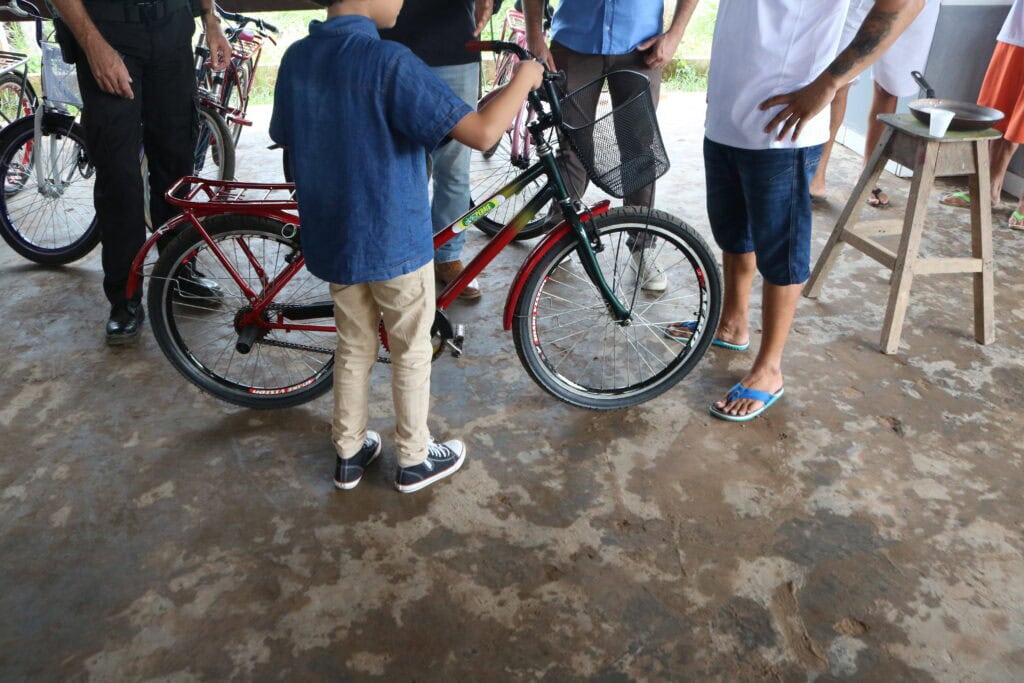 Filho do detento W. M recebendo bicicleta do projeto. Foto: José Lucas Gaia/Iapen