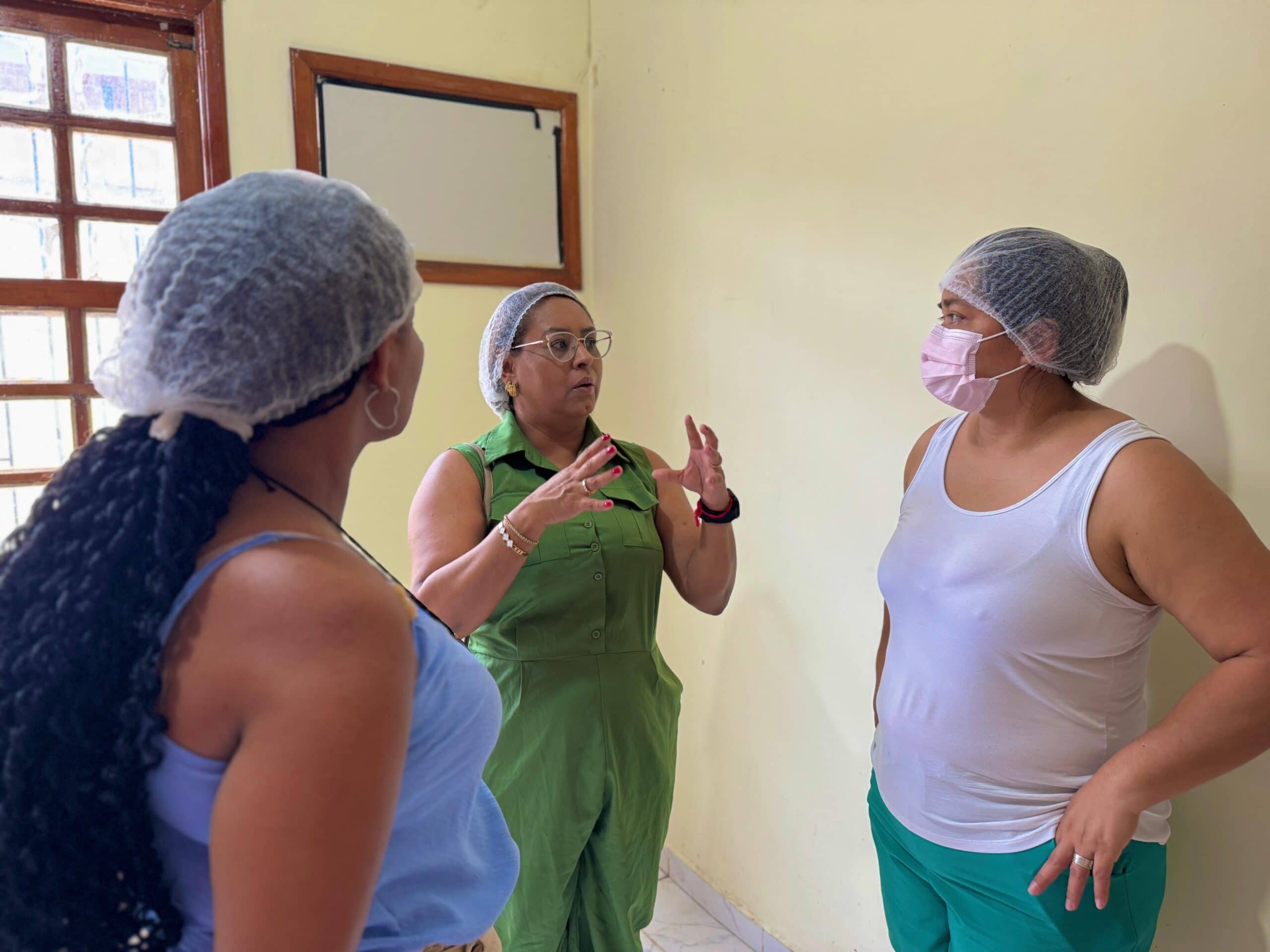 Nilciany Vilaço (de verde) conversando com responsáveis pela cozinha no Habitasa. Foto: Carolina Torres/Secom